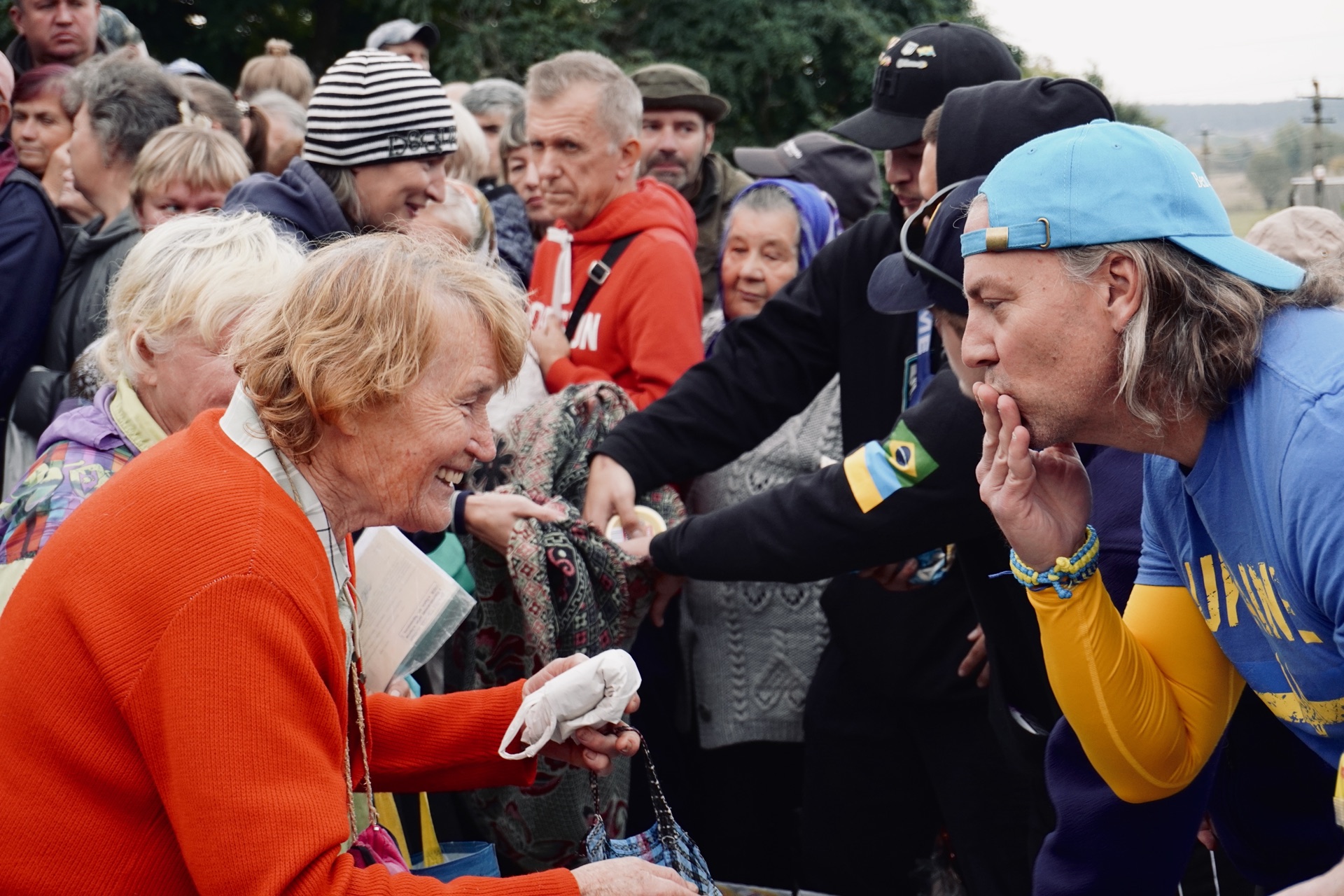 An elderly Ukrainian woman smiling during an aid distribution in the Kharkiv region