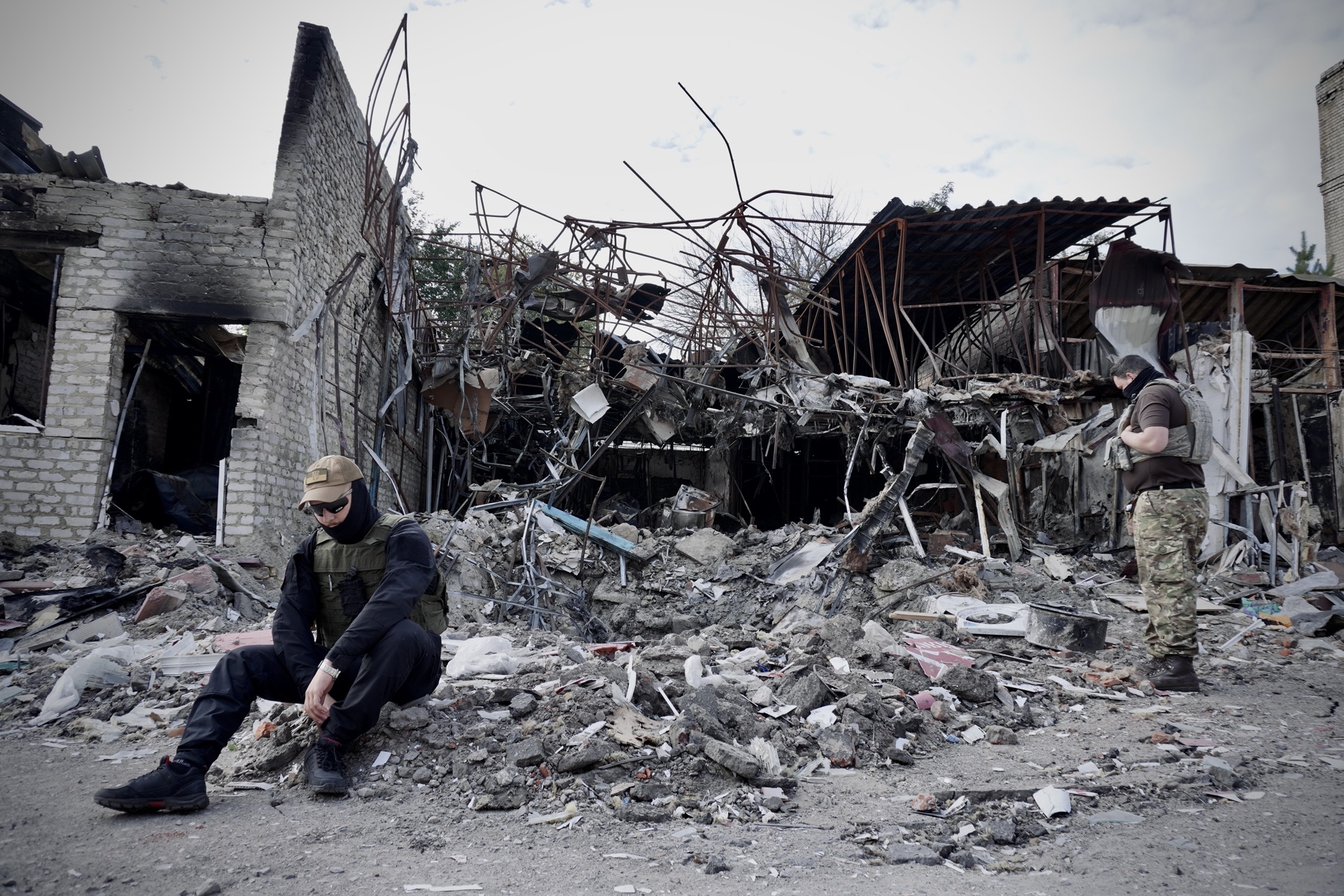 Two fighters amid the rubble of destroyed buildings in Kupiansk
