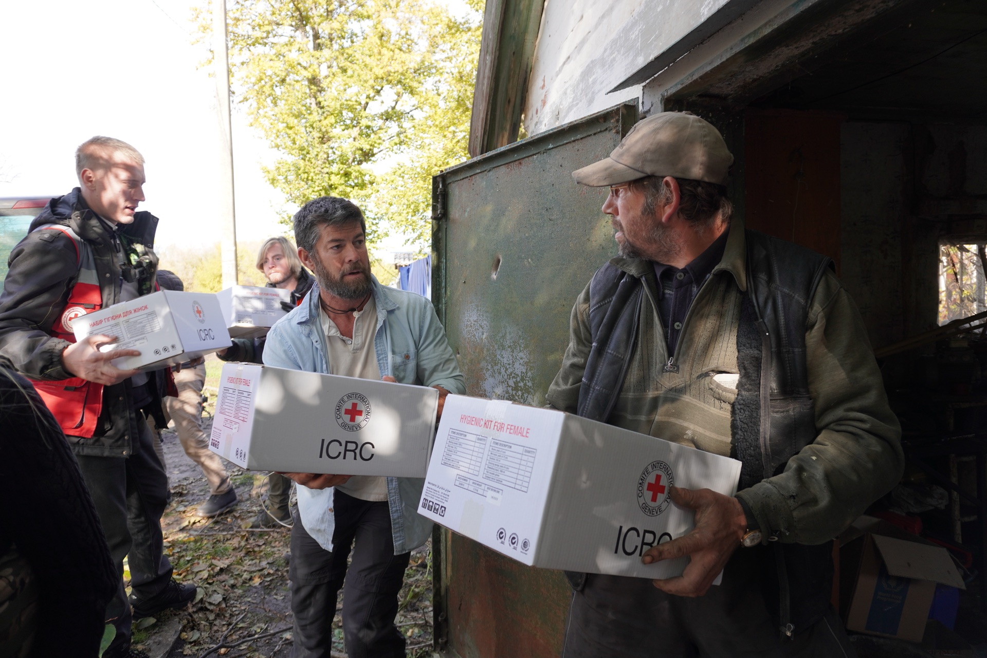 Aid workers distributing ICRC food parcels to a resident near Pershotravneve